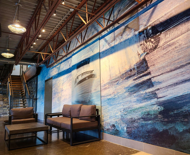 A graphic image of a boat on water directly printed on Amplify custom wallcovering and Oomph sound absorbing wall panels.