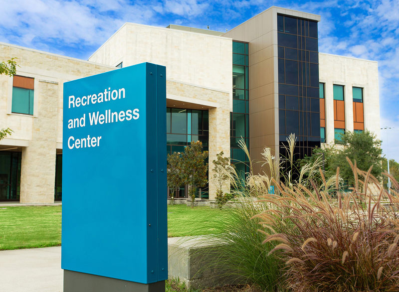 An exterior wayfinding sign designed to compliment the building architecture on a higher education campus.