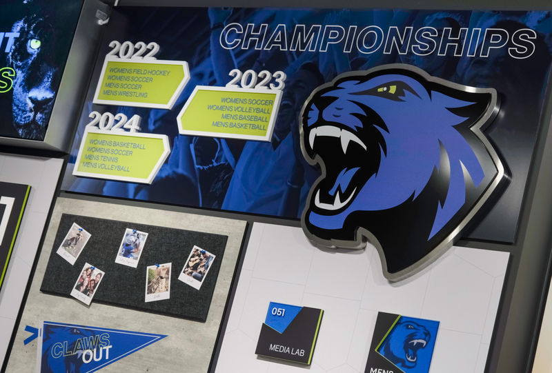 Custom fabricated stainless steel Jaguar logo, interior signage and other school branded experiential graphics.