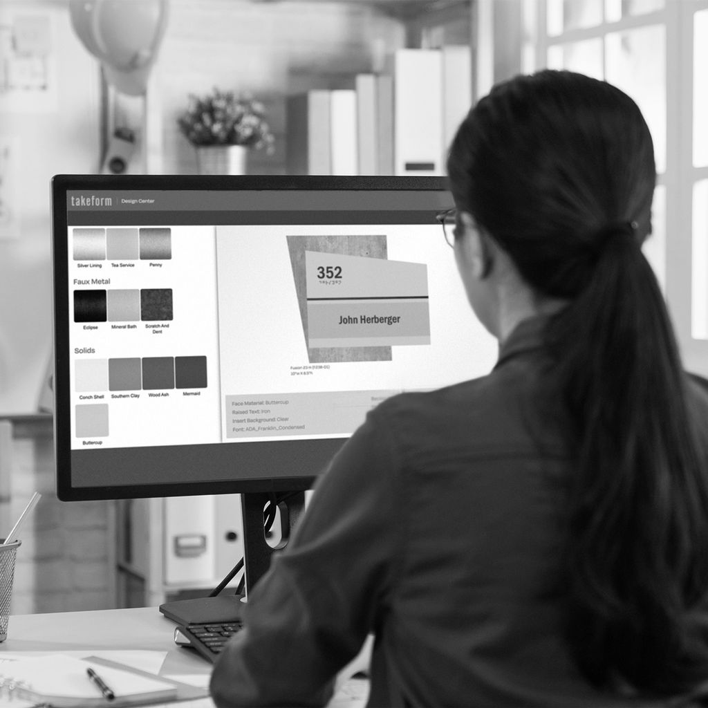 Designer at their desk designing a sign in Takeform's Design Center