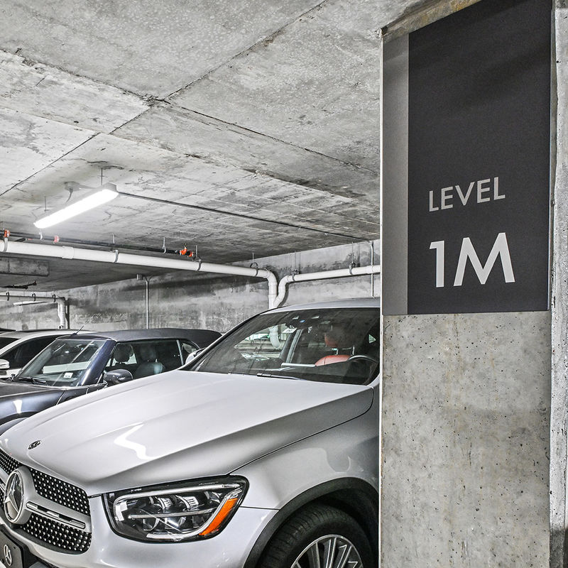 A clean minimalist level indicator sign mounted to a column in a parking garage ramp