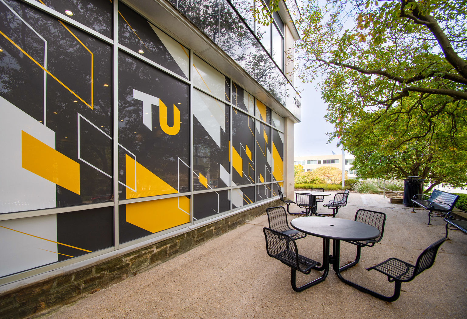 Perforated window film custom printed with school brand graphics viewed from outside the school courtyard.