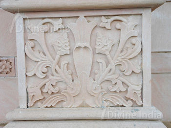 Wall sculpture from a stone in the form of a flower on walls