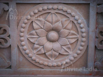 Wall sculpture from a stone in the form of a flower on walls