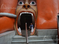 The entrance of the temple has an open mouth Rakshas or a monster in a slain condition at the death bed at 108 Feet Hanuman Temple