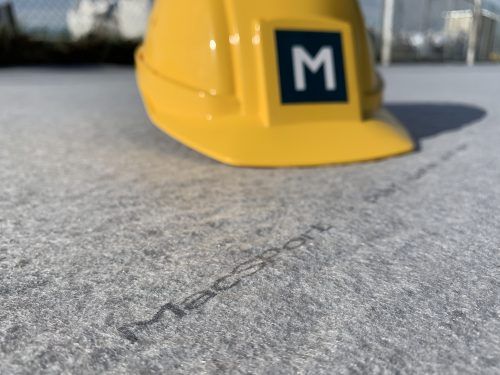 MacSport branded helmet resting on the installed synthetic turf drainage system