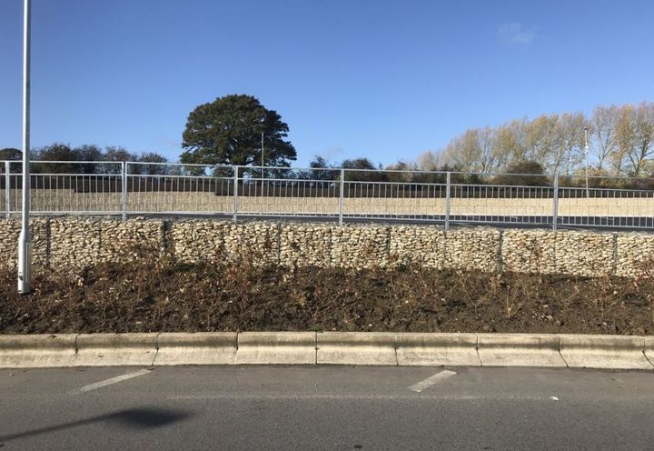 The wall surrounding the slip road and then the HGV parking area