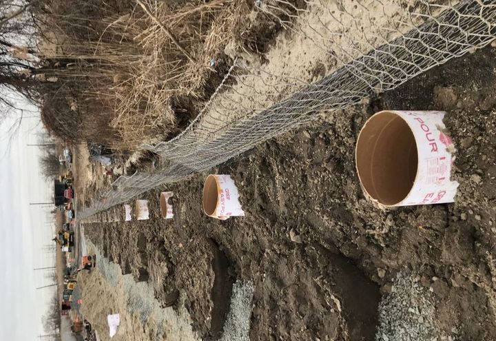 Green TerraMesh filled with soil. Note: the sonotubes are for fenceposts