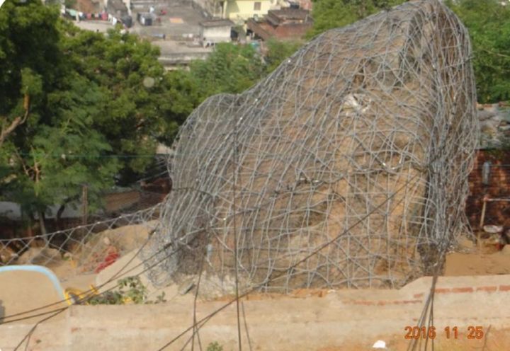 Figure 2- Boulder covered with the meshes and mesh fence on side