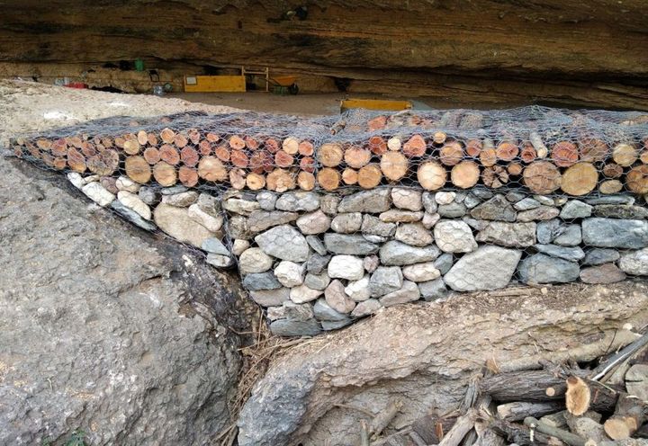 Vista muro; parte inferior piedras, parte superior troncos