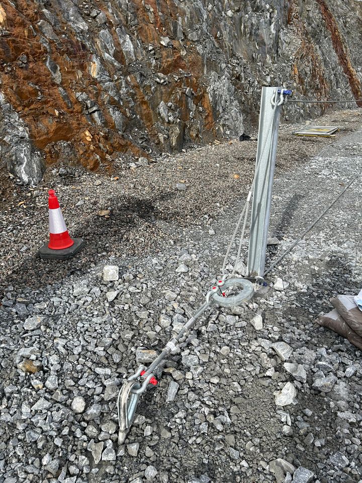 Energy dissipating device connected to lateral anchor