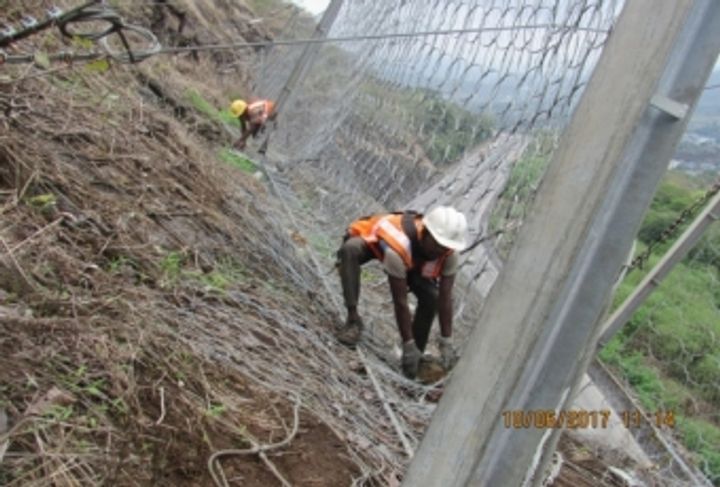 Photo 6: Cleaning off the debris from upslope side of the rockfall barrier