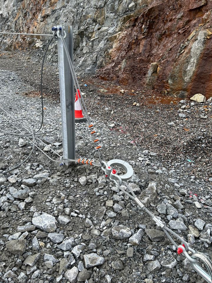 Energy dissipating device connected to lateral anchor