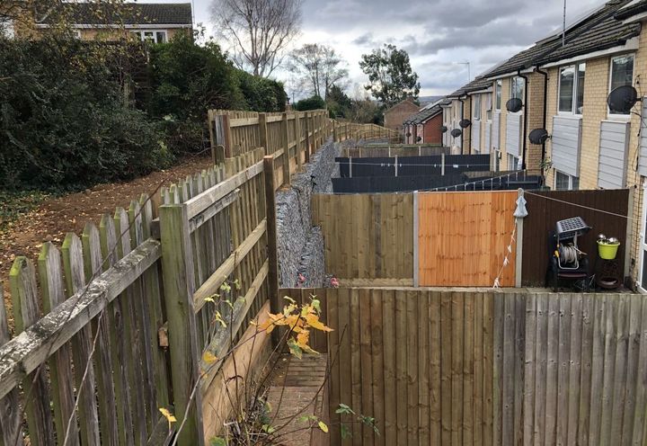 Finished gabion wall stretching along the line of properties