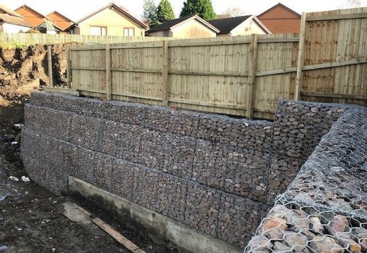 The wall retaining and with a 6ft fence on top to surround the car park behind 