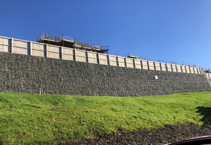 At the back of the houses the wall stands tall in the distance