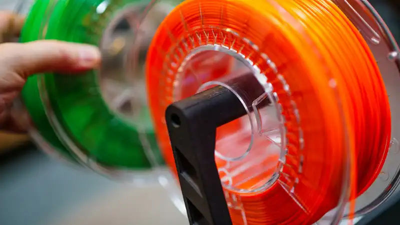 Various 3D printing materials like PLA, ABS, resin, and metal powder used in manufacturing