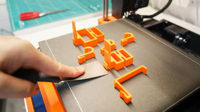 Beginner using desktop 3D printer in home workshop environment