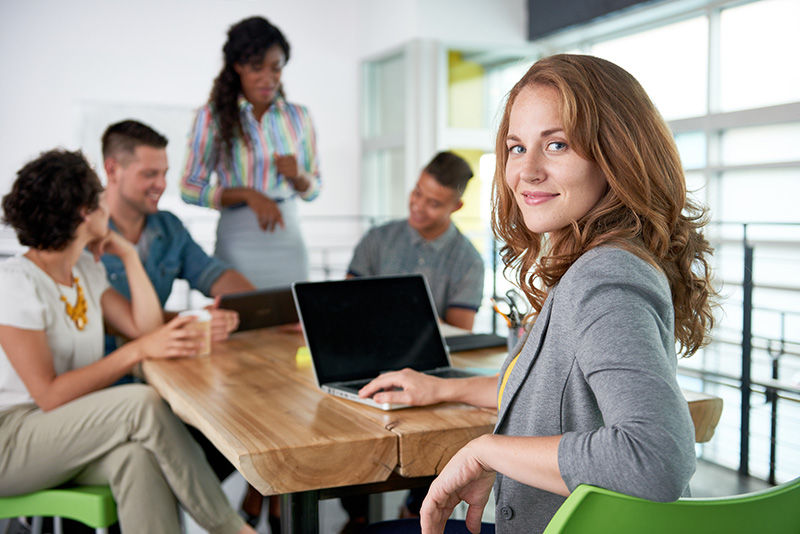 Creative blond businesswoman leading hes team in a friendly conversation about their next agency project