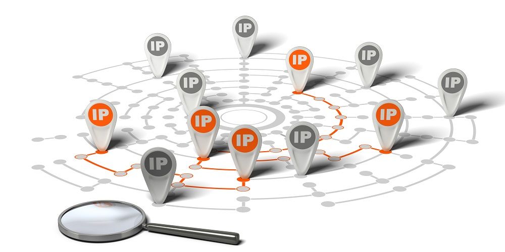 Many flags withe the word IP pined on network over white background and a magnifier. Concept image for illustration of IP tracking.