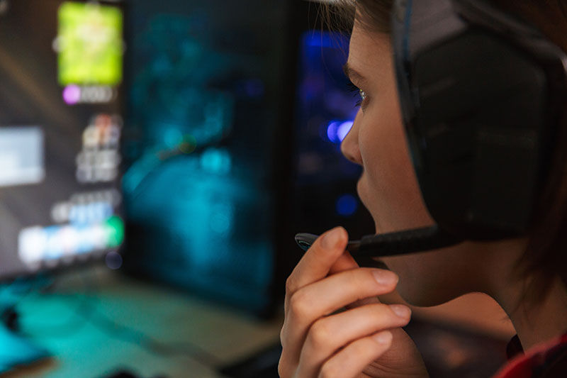 Close up of a nervous angry young woman gamer playing online computer games at the table