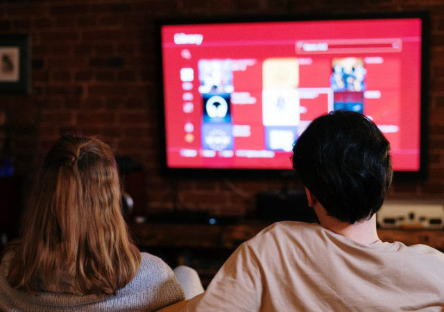 a couple watching streamed movies on a TV