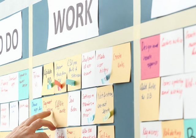 Young man near scrum task board in office