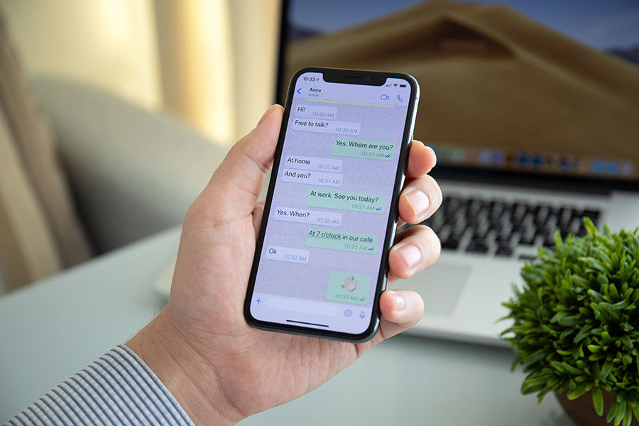 Alushta, Russia - October 9, 2018: Man holding iPhone X with social networking service WhatsApp on the screen. iPhone 10 was created and developed by the Apple inc.