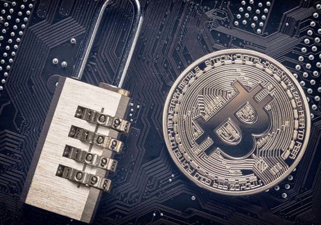 Bitcoin with padlock on computer motherboard. Crypto currency Internet data privacy information security concept