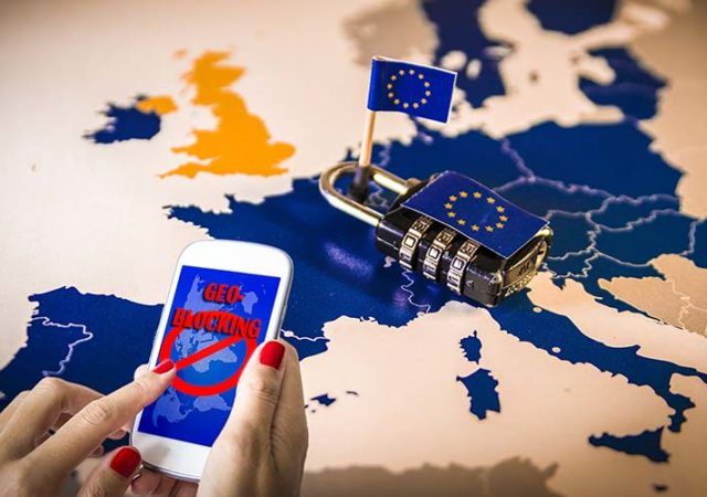 Female hands using a smartphone with geoblocking on screen and Padlock over EU map. European Union Digital single market and regulation against Geo-blocking and geographically-based restrictions