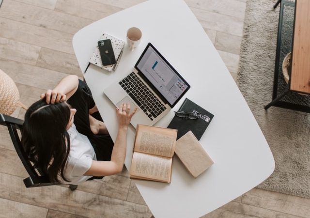 Young lady using laptop at table in modern workspace