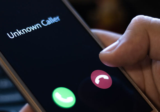 Unknown caller. A man holds a phone in his hand and thinks to end the call. Incoming from an unknown number at night. Incognito or anonymous