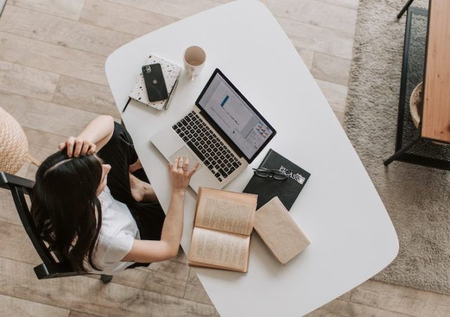 Young lady using laptop at table in modern workspace