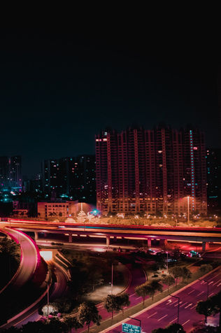 A light-stained highway and city at night.