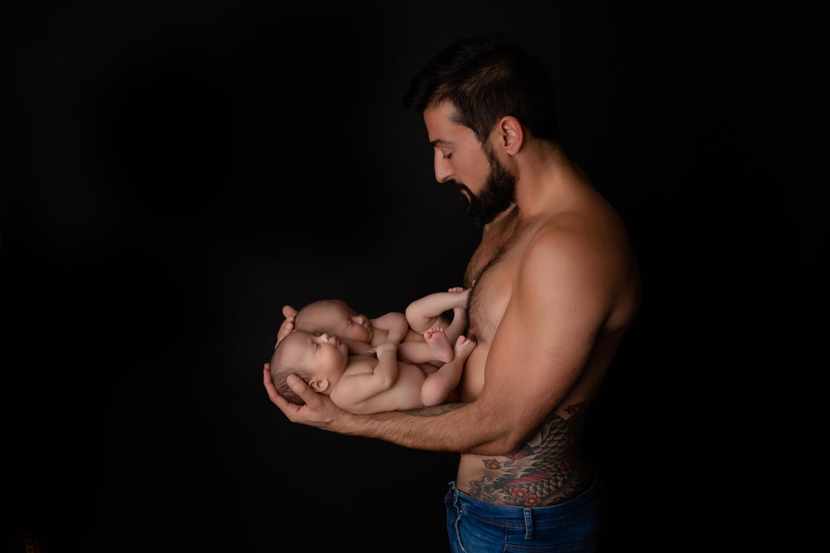Father holding his newborn twins — the complete gay dad surrogacy journey