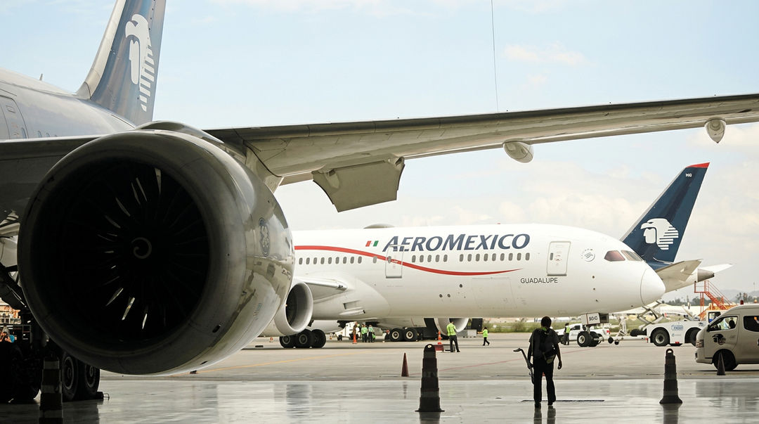 Aeromexico ends its Tulum flights at the close of September Commercial aircraft parked at an airport tarmac with ground service vehicles and personnel nearby