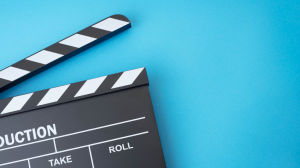 Clapperboard on a light blue background.