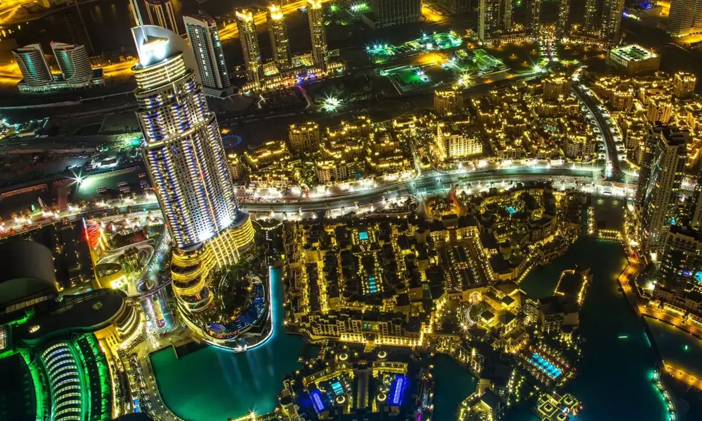 Night view from the top, showing Dubai illuminated with city lights stretching to the horizon.