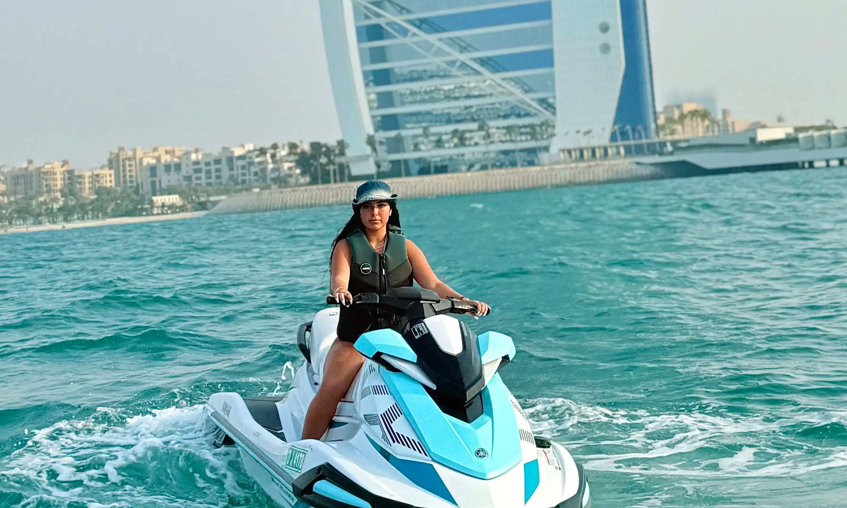 Adventure seeker riding a jet ski near Palm Jumeirah with Dubai skyline views.