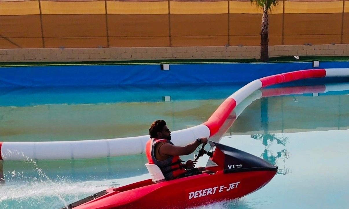 Close-up of a jet ski cutting through water against the backdrop of desert landscapes.