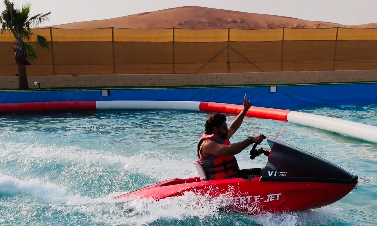 Adventurer racing on a jet ski surrounded by golden sand dunes in Dubai.