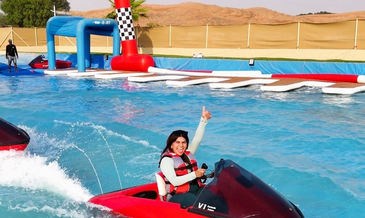 Rider on a desert jet ski track in Dubai completing laps with sand dunes in the background.
