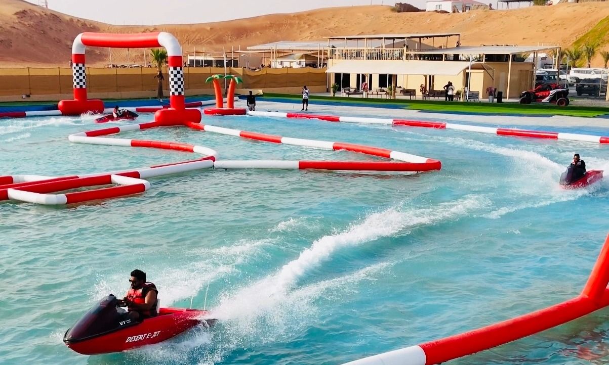 Adventurer racing on a jet ski surrounded by golden sand dunes in Dubai.