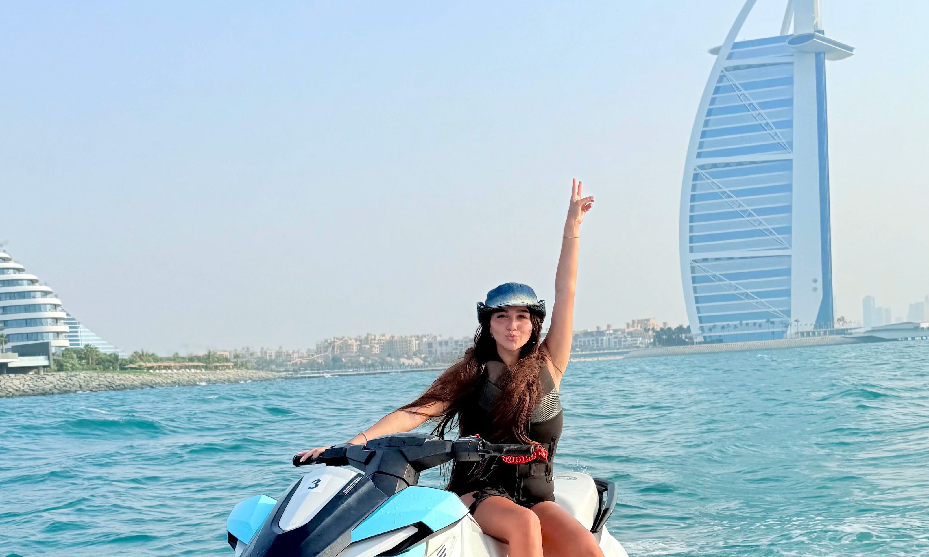Tourist enjoying a Dubai jet ski ride with Burj Al Arab in the background.