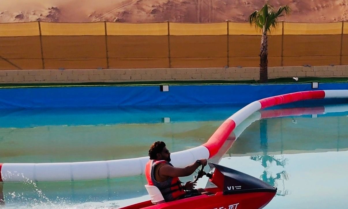Close-up of a jet ski cutting through water against the backdrop of desert landscapes.