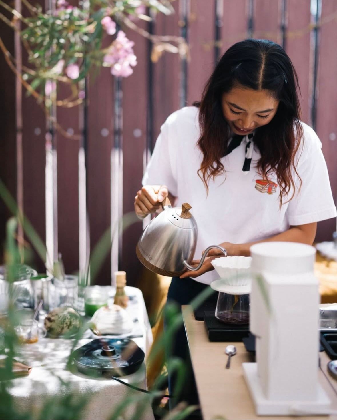yumi crafting pour-over in the outside garden at the coffee0