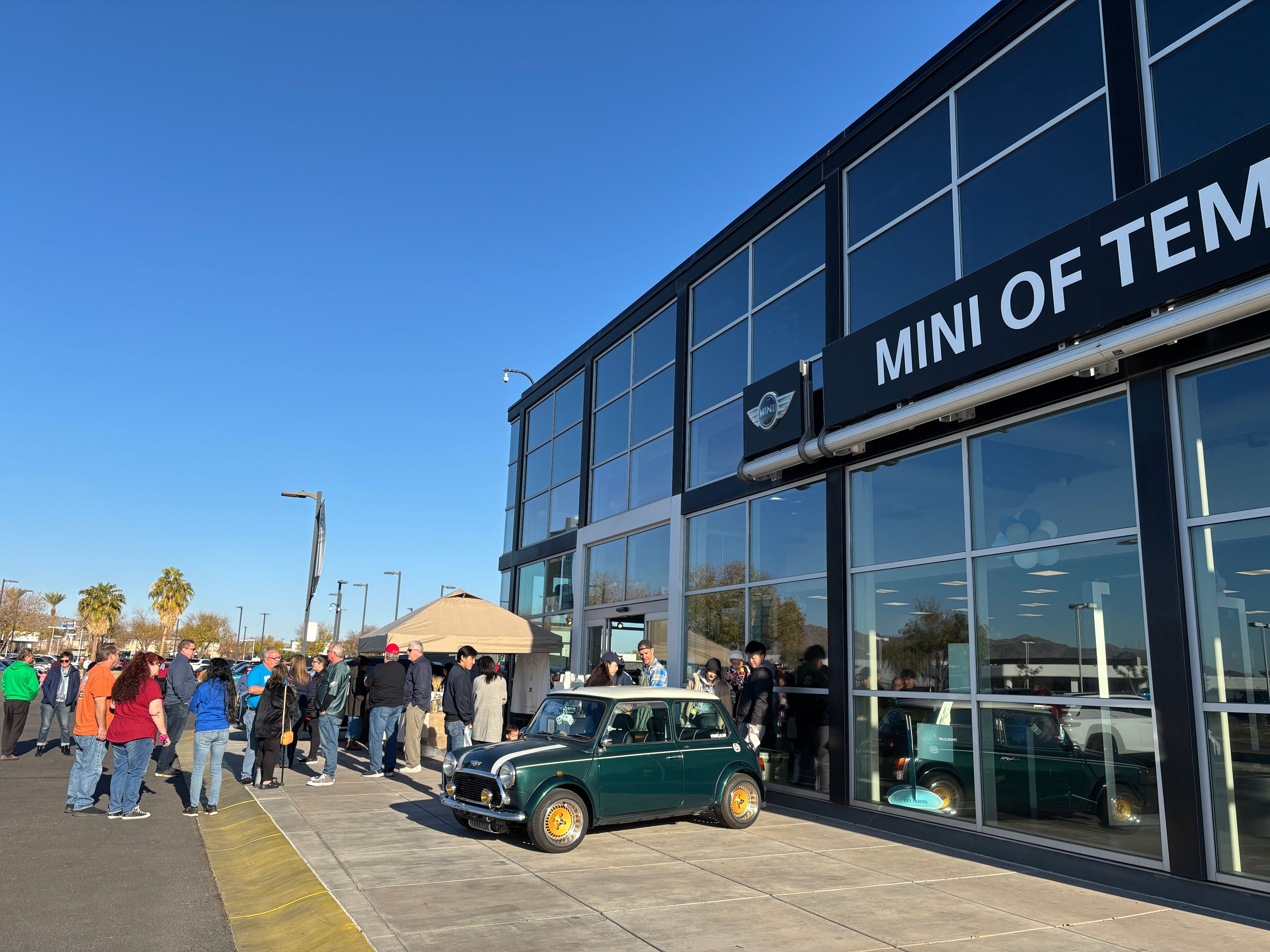 wide shot of the mini cooper store with people standing in the line for the yumi's coffee