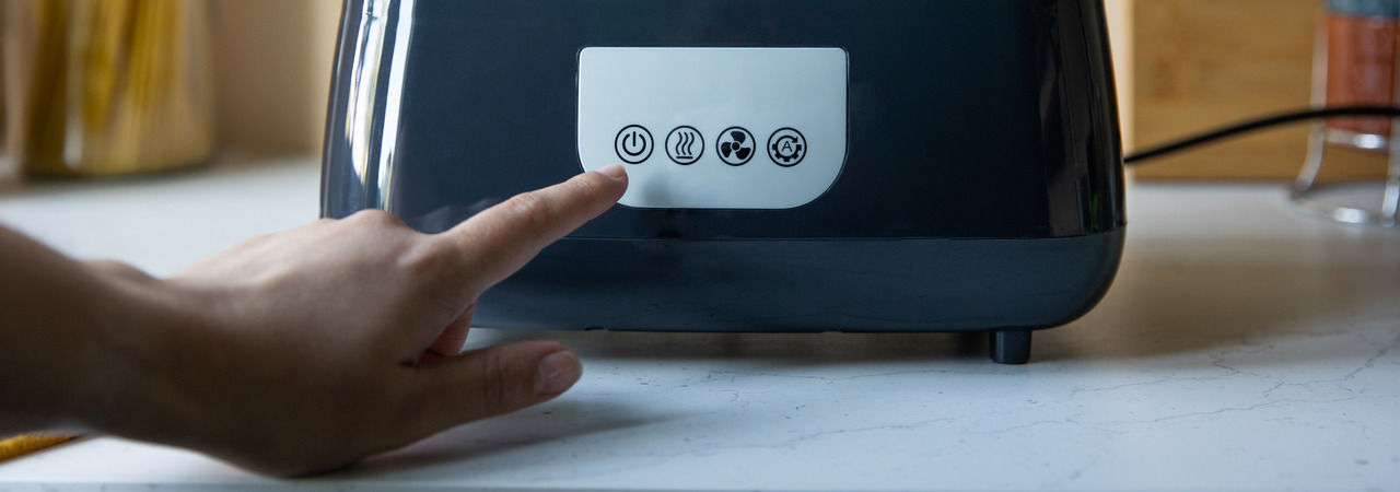 Somebody's hand in front of the controls panel on the Steridryer Electric Steam Steriliser & Dryer about to press the power button