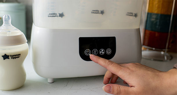 Mother pressing power button on Advanced Steri-Dryer Electric Sterilizer