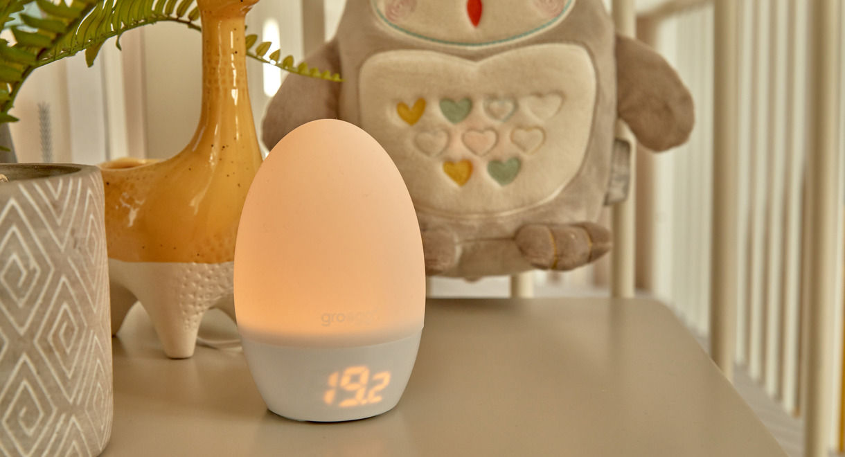 Groegg on bedside table with Grofriend in the background hanging from cot